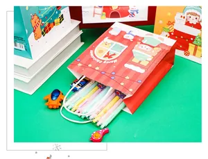 Christmas gift bags with cartoon patterns, matching pens on green background