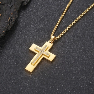 Macro view of gold cross pendant necklace featuring inlaid zircons and a double layer design