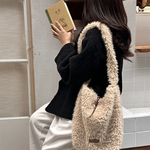 Detail of beige faux shearling tote bag with brown drawstring and brand leather tag