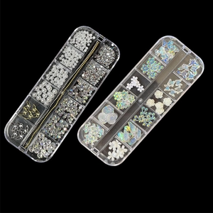 Detailed assortment of nail art beads, metal butterflies and floral rhinestones in clear box