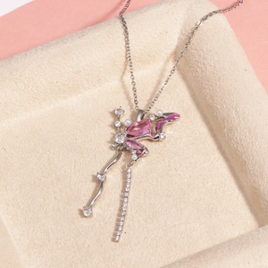 Détail d'un collier argenté avec pendentif papillon rose, perles et zircons brillants