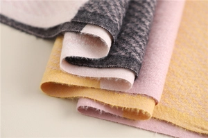 Detailed macro view of soft plaid knit fabric in pink, yellow, and grey color tones