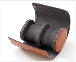 Detail of brown leather watch roll featuring soft grey suede lining and white stitching