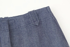 Detail der blauen Fischgrät-Stofftaille mit Gürtelschlaufen und präziser Naht