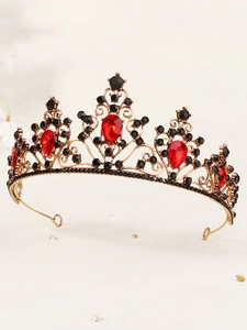 Macro detail of vintage gold alloy tiara with red pear-cut gems and black rhinestones