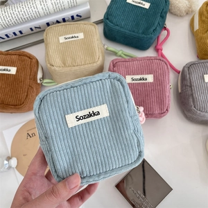 Detail shot of corduroy texture on colorful cosmetic bags with brand labels