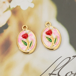 Macro detail of 18K gold-plated oval tulip pendants with red oil drip and small pearl inlay