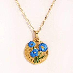 Détail du collier vintage doré avec pendentif tulipe en émail bleu sur fond blanc