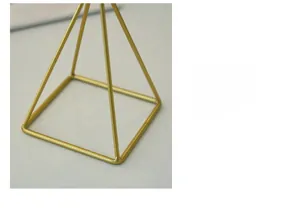 Detail of golden geometric candle holder base with smooth square metal structure