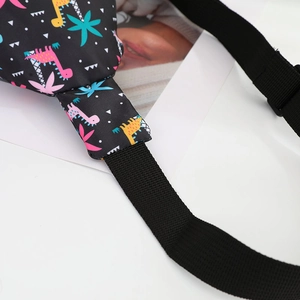 Detail shot of black nylon chest bag with colorful dinosaur print and reinforced stitching