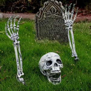 Halloween skeleton yard stakes set with realistic skull, arm bones and a tombstone on grass