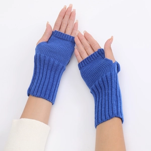 Detail of royal blue knitted fingerless gloves with bow accent and warm wool texture