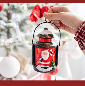 Close-up of a festive red Christmas lantern with Santa Claus and metal hanging ring