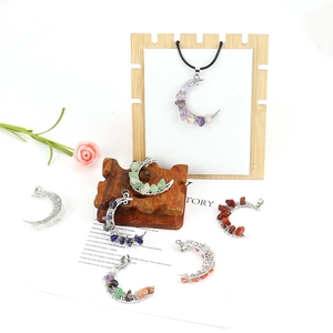 Detail of moon-shaped chakra pendants with natural crystal stones on a wooden display