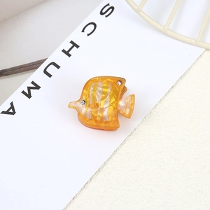 Creative fish-shaped acetate hair clip with orange amber texture and rhinestone eye detail
