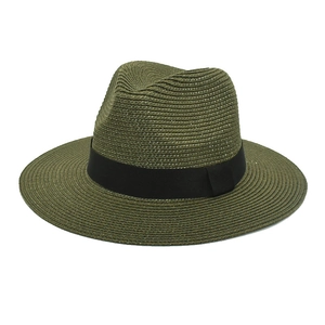 Detail of dark green straw fedora hat with black ribbon showing woven texture