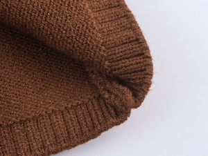 Macro view of caramel brown knit beanie showing detailed ribbed texture and soft thick yarn