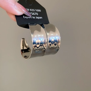 Nahaufnahme glänzender C-förmiger Creolen aus 925er Sterlingsilber mit poliertem Finish