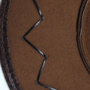 Macro shot of dark brown suede cowboy hat with black leather wavy stitching details