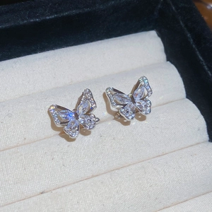 Detail view of silver butterfly ear clips with zircon inlay in a velvet jewelry box