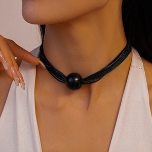 Detail shot of a minimalist black multi-layer choker necklace with a large glossy bead