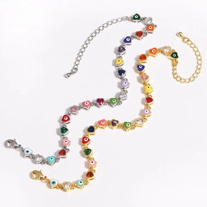 Detailed view of gold and silver heart-shaped bracelets featuring colorful evil eye motifs
