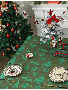 Detailed pattern of green Christmas lace tablecloth featuring Santa, reindeer and snowflakes