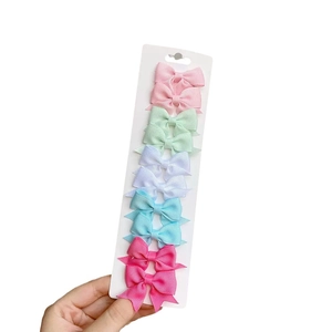 Set of 8 colorful grosgrain ribbon bow hair clips for baby girls on a display card