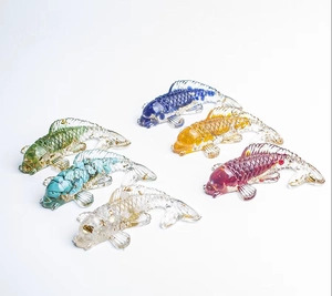 Détail macro de six ornements de carpes koï en résine avec cristaux colorés et feuilles d'or