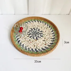 Detail of round rattan tray with mosaic shell inlay design measuring 35cm in diameter