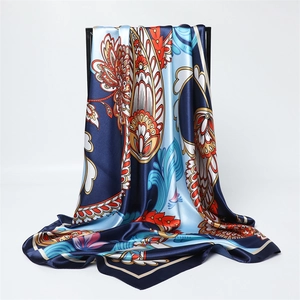 Dettaglio sciarpa in raso con stampa paisley in blu navy, azzurro e tonalità oro