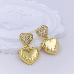 Detail of gold double heart earrings with crystal pavé and polished metal textures