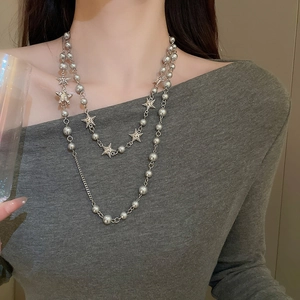 Detail of layered star charm necklace with silver beads and shimmering star pendants