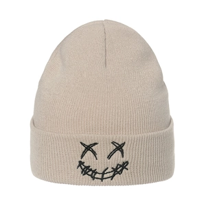 Beige knit beanie with black embroidered ghost face showing detailed ribbed texture