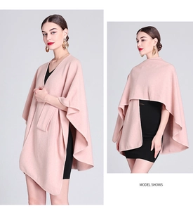 Detail view of a pink knit poncho cape with a loose fit and soft texture for women