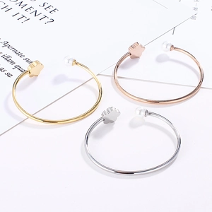 Detailed view of C-shaped stainless steel flower bracelets with white pearls in three colors