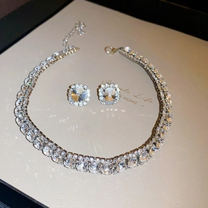 Detailed view of vintage jewelry set with rhinestone flower necklace and stud earrings