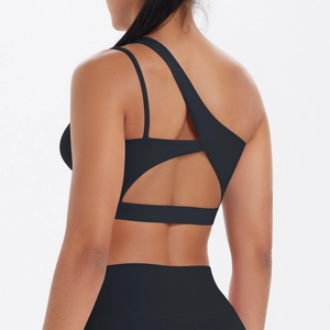 Detail of black one-shoulder sports bra with back cutout and high-stretch matte fabric