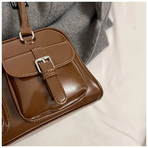 Detailed close-up of dark brown PU leather texture and silver buckle on a pillow bag