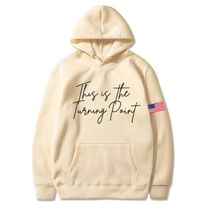 Detail eines beigen Mirada Hoodies mit 'This is the Turning Point' Text und Ärmel-Flaggen-Patch