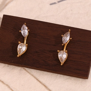 Detailed close-up of 18K gold earrings with sparkling teardrop-shaped zircon gemstones