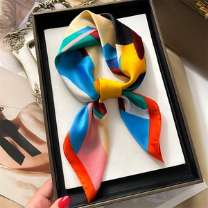 Detailed view of colorful printed silk scarf styled as an elegant necktie bow