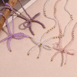 Handmade beaded bow necklace set featuring faceted purple and pink crystals with gold beads