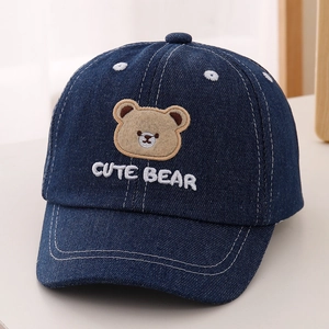 Detail of blue denim kids baseball cap with plush bear embroidery and cute bear text