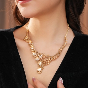 Gros plan d'un collier doré avec cristaux scintillants sur une robe en velours noir