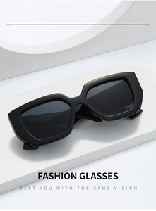 Close-up of rectangular matte black sunglasses with dark lenses on minimalist white cubes