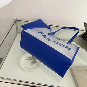 Blue and transparent fashion tote bag set with FASHION lettering on glass table