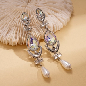 Detailed shot of teardrop faux pearls and iridescent crystals on silver earrings