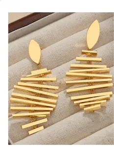 Detailed close-up of 18K gold plated fishbone earrings on a velvet jewelry box