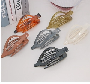 Close-up of 6 hollow leaf design hair claws in transparent brown, amber and solid cream